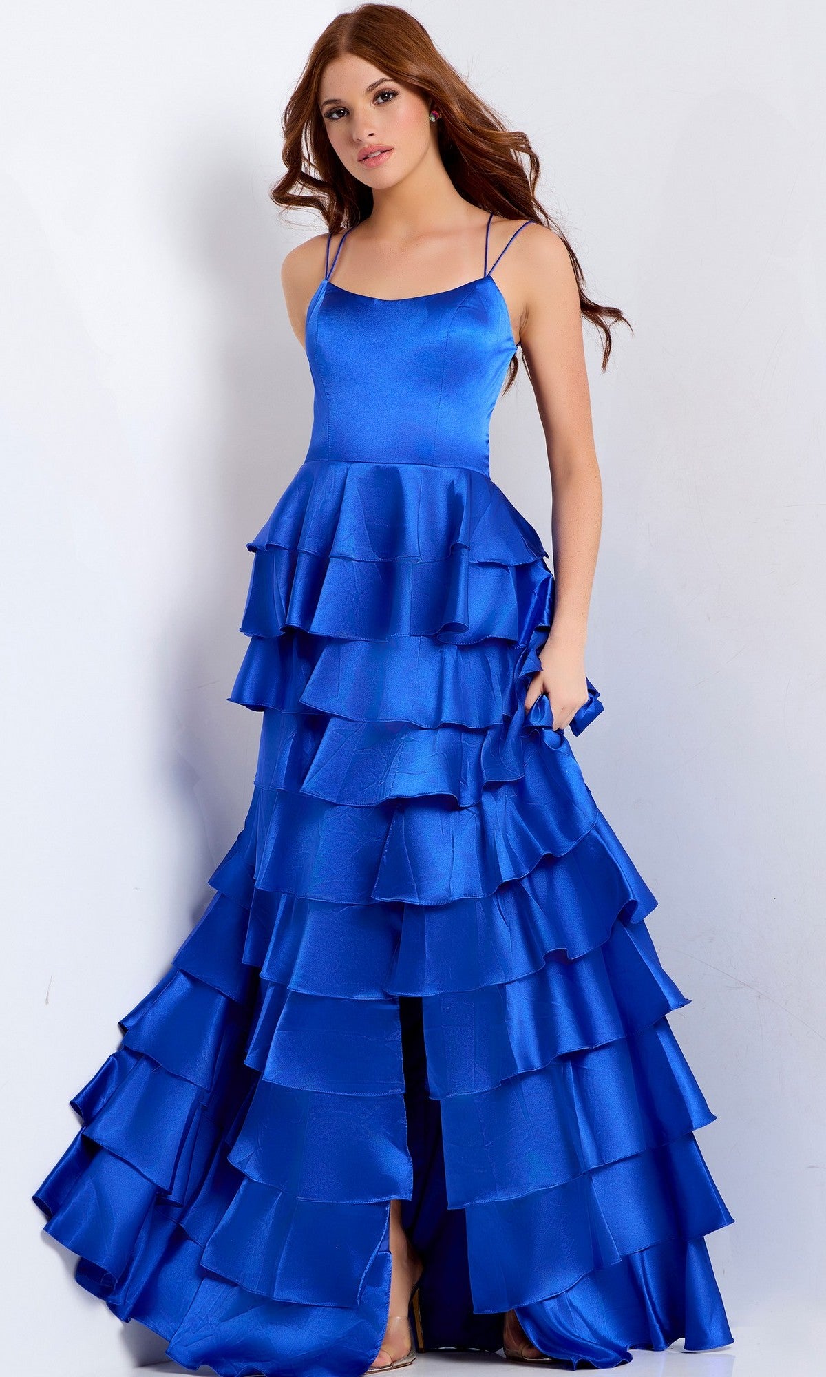 A woman in a Jovani 48295 long prom dress featuring a sleeveless, tiered ruffle skirt and strappy lace-up back stands against a plain light background.
